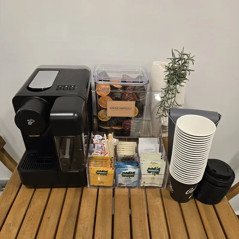 Kaffeemaschine, Teebeutel und Pappbecher in der Getränkeecke